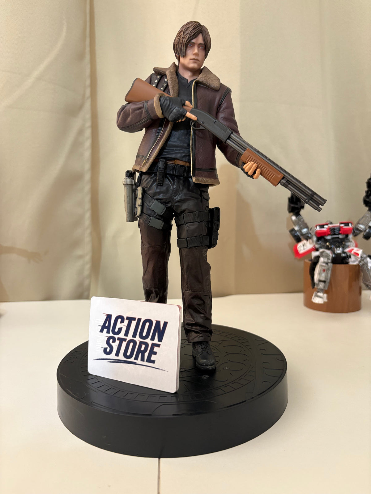 Resident Evil 4 Leon S Kennedy action figure holding shotgun in brown bomber jacket on RPD base close up front view